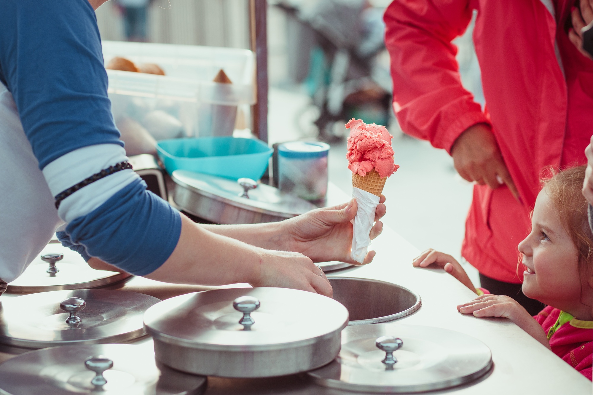 Little girl waiting for icecream. Mom buying a ice cream her little daughter in candy shop by street