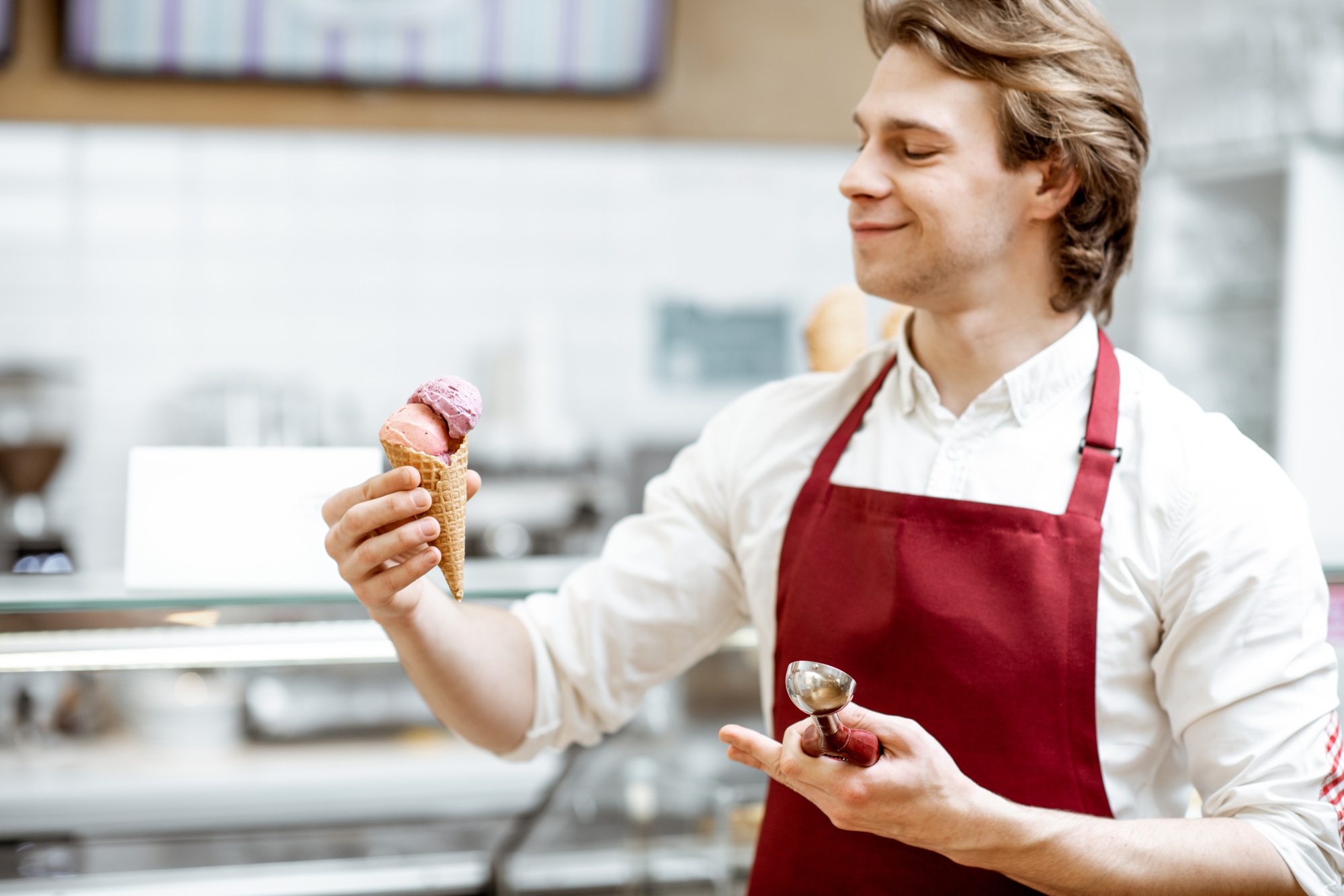 Salesman with ice cream in the shop